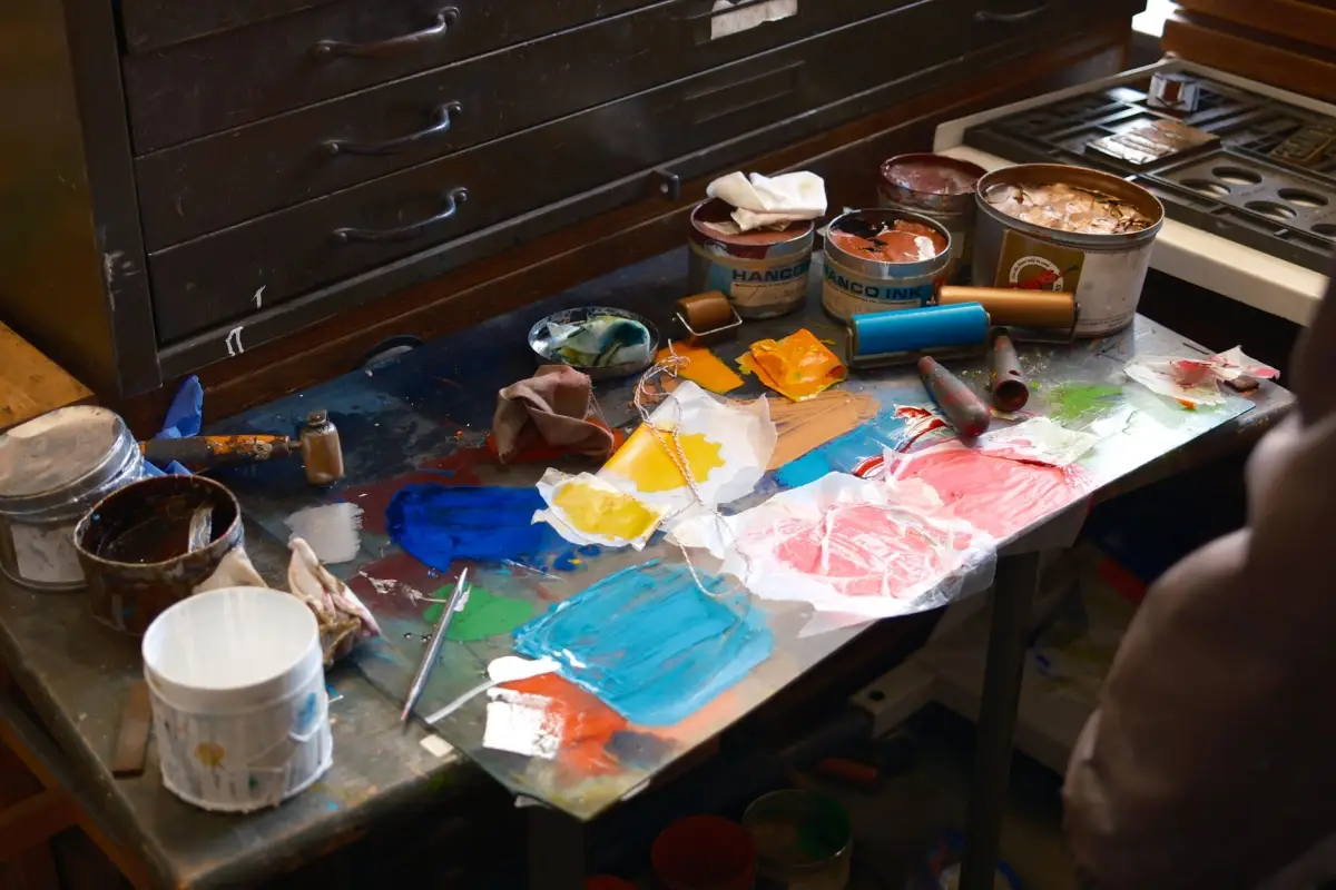 Pots de peinture, brosses et outils de patine sur un plan de travail